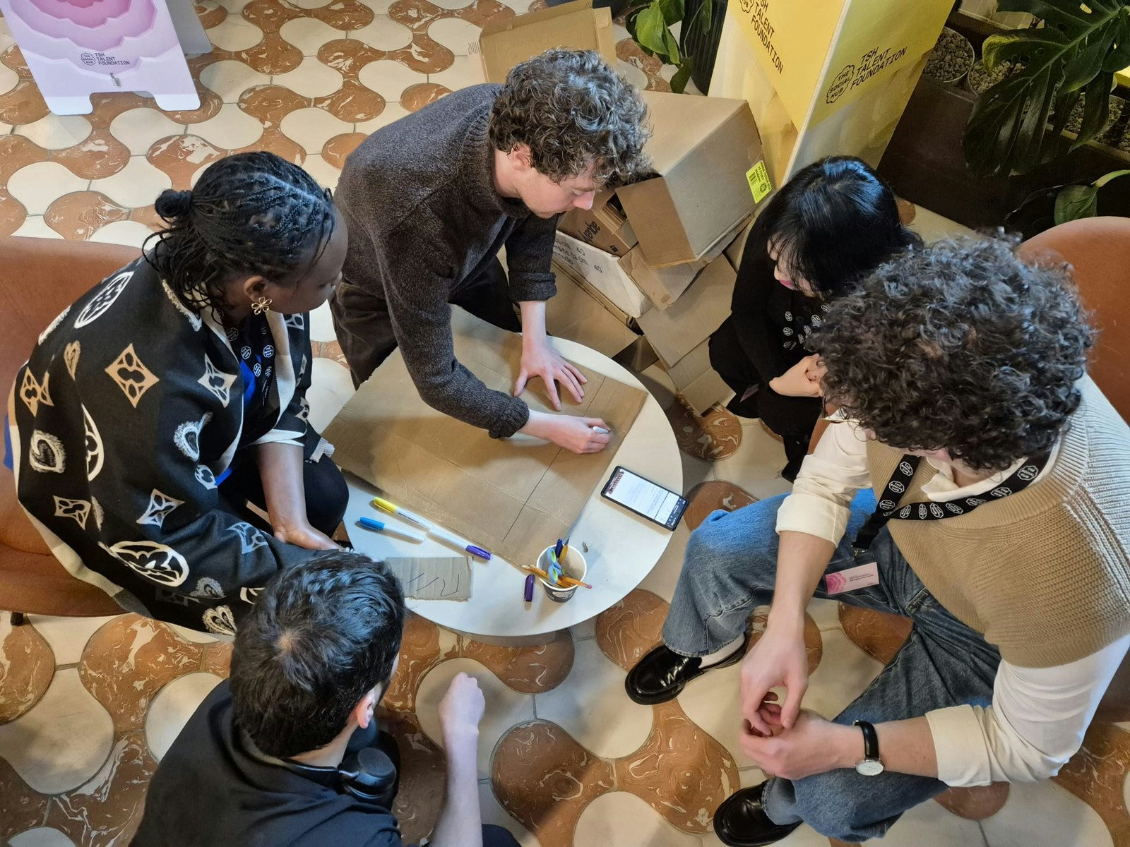A team at the Better Society Academy in Rome sketching a conversational object on cardboard